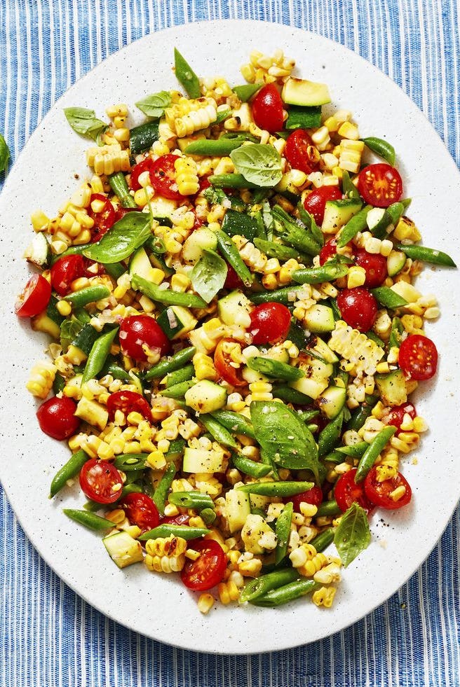 corn, red small tomatoes, zucchini and green beans on a white plate