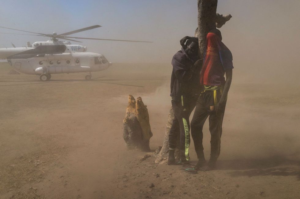 Bij het opstijgen vanaf het eiland Kok werpt een helikopter met voedselhulp stofwolken op Op het eiland in de Sudd leven duizenden ontheemden