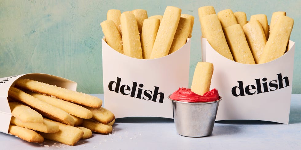 sugar cookies shaped as fries in a container dipped in red icing
