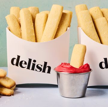 sugar cookies shaped as fries in a container dipped in red icing