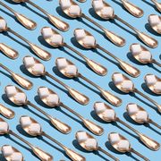 sugar cubes in metallic spoons on the blue background