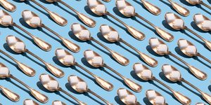 sugar cubes in metallic spoons on the blue background
