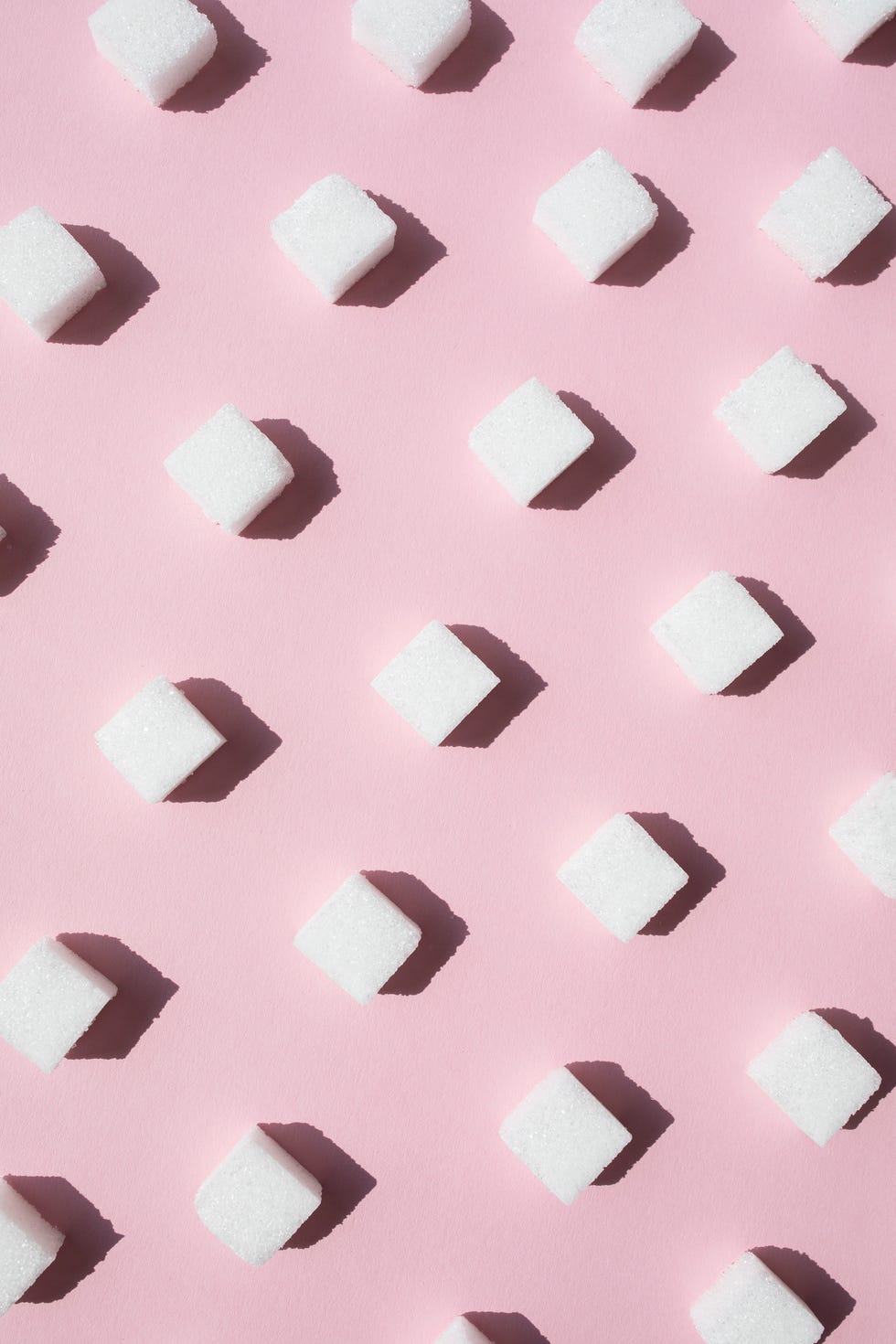 Sugar cubes on pink background