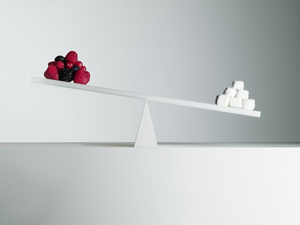sugar cubes tipping seesaw with berries on opposite end