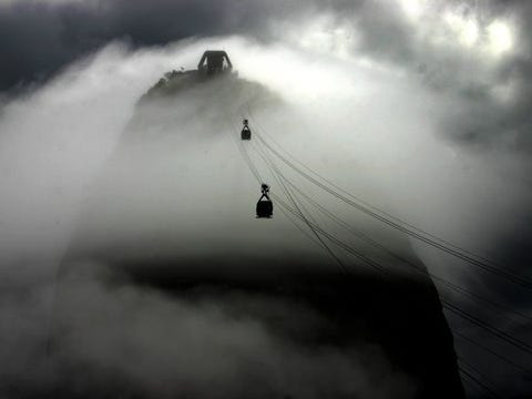 Kabelbanen naar de Sugarloafberg Kabelbanen dalen door de lage wolken af naar de Po de Ajar suikerbroodberg een typisch symbool van Rio Het herkenningspunt dat eigenlijk uit twee bergen bestaat is sinds 1912 te bereiken met een kabelbaan