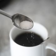 study sugar significantly raises risk of heart disease, stroke, sugar on coffee spoon in front of mug with black coffee