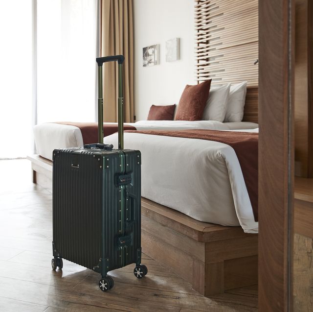 suitcase by bed in hotel room