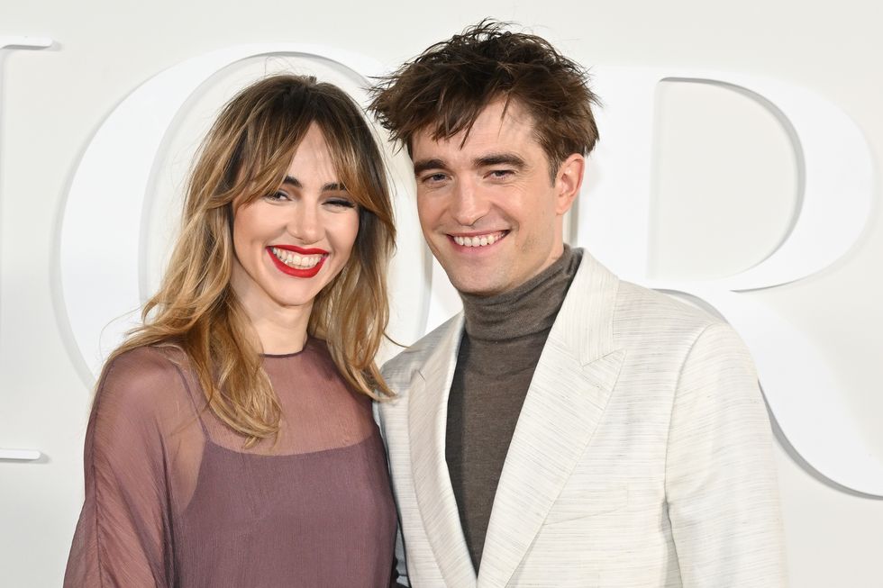 suki waterhouse and robert pattinson stand together and smile for photos