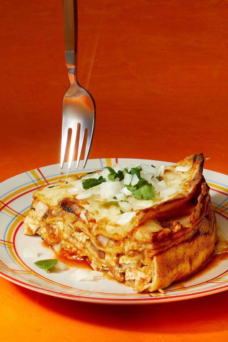 chicken enchilada pie on a plate with diced white onion on top