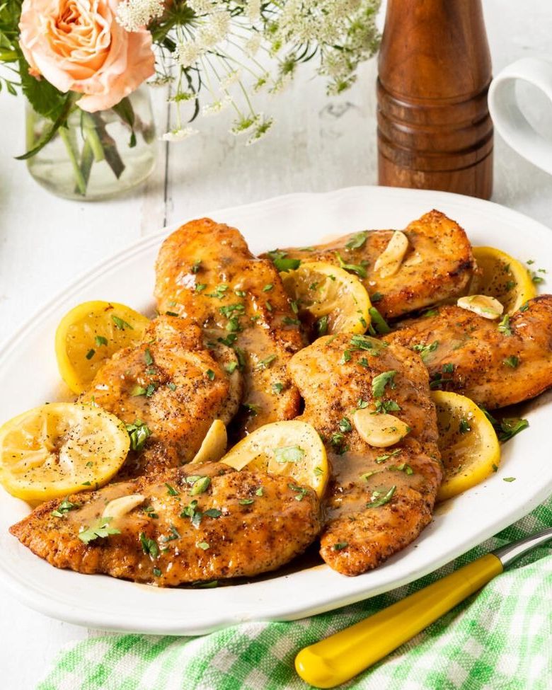 lemon pepper chicken breasts on platter with lemon wedges