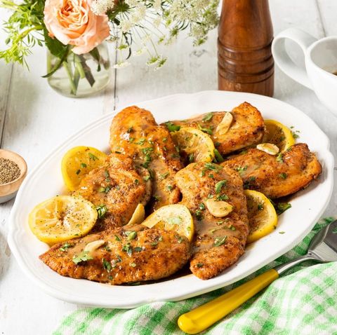 lemon pepper chicken breasts on platter with lemon wedges