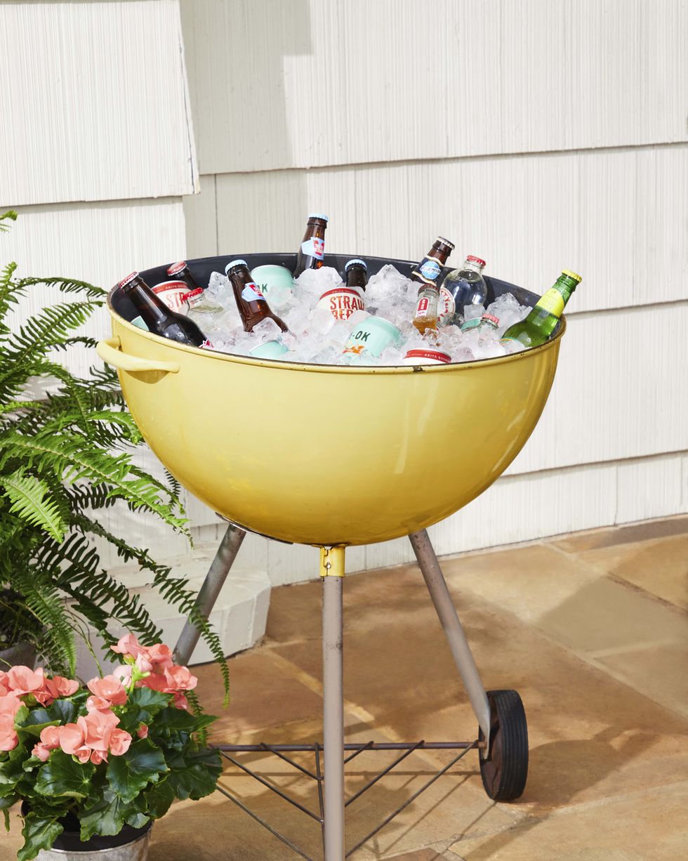 vintage weber kettle grill turned into a cooler filled with ice and drinks
