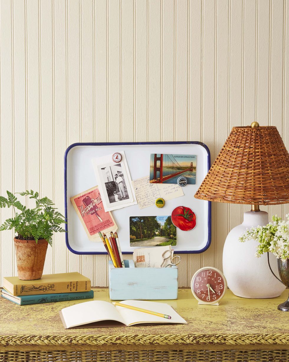 enamelware platter turned into a memo board for a summer crafts project hangs above a yellow wicker desk