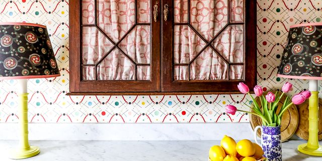 counter with colorful wallpaper, cabinets, and flowers