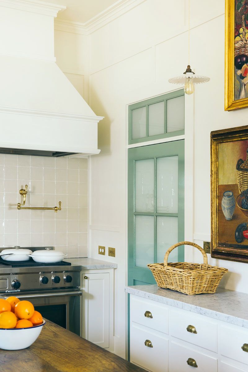 kitchen with mint green door and bowl of oranges