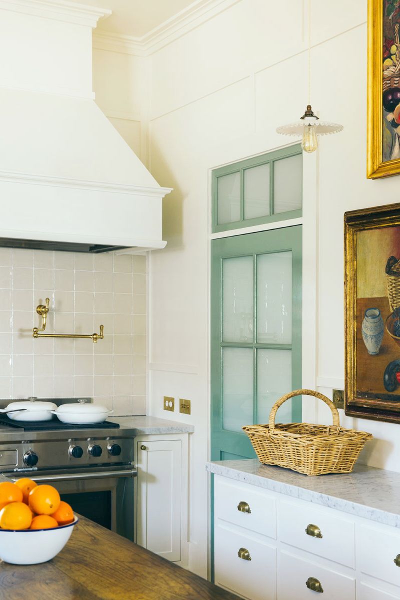 kitchen with mint green door and bowl of oranges