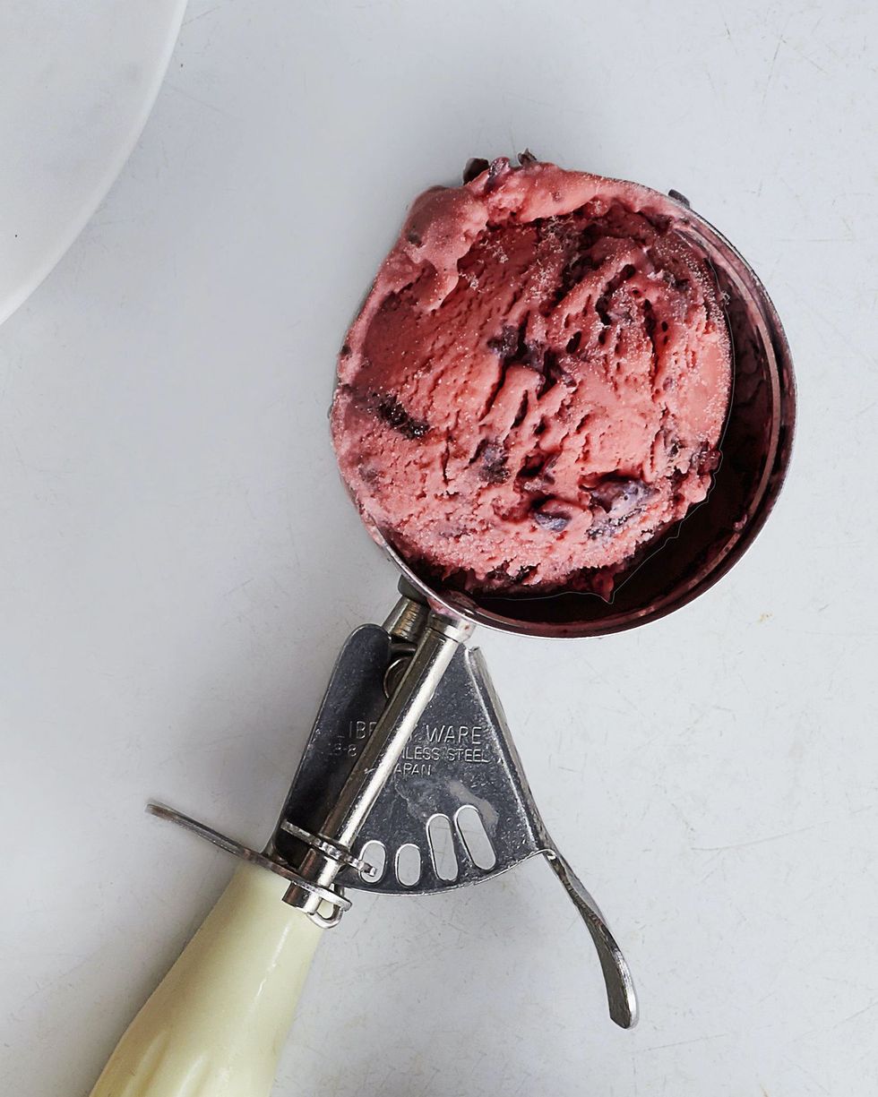 a scoop of cherries jubilee ice cream in an ice cream scooper
