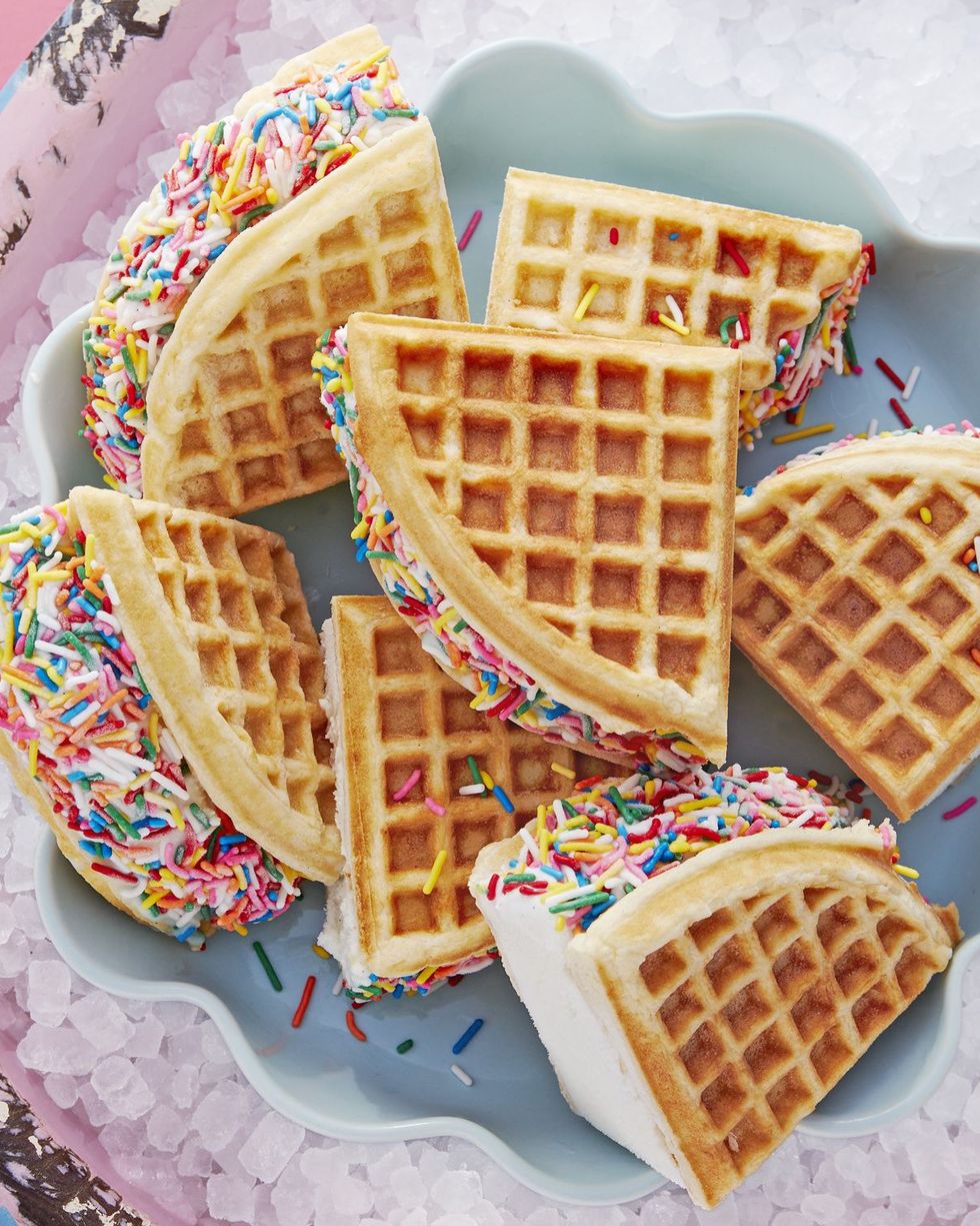 rainbow waffle ice cream sandwiches on a light blue dish in a container with ice