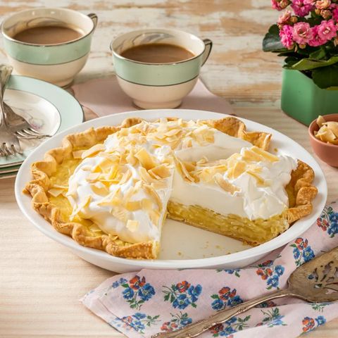 coconut cream pie with mugs of coffee in back