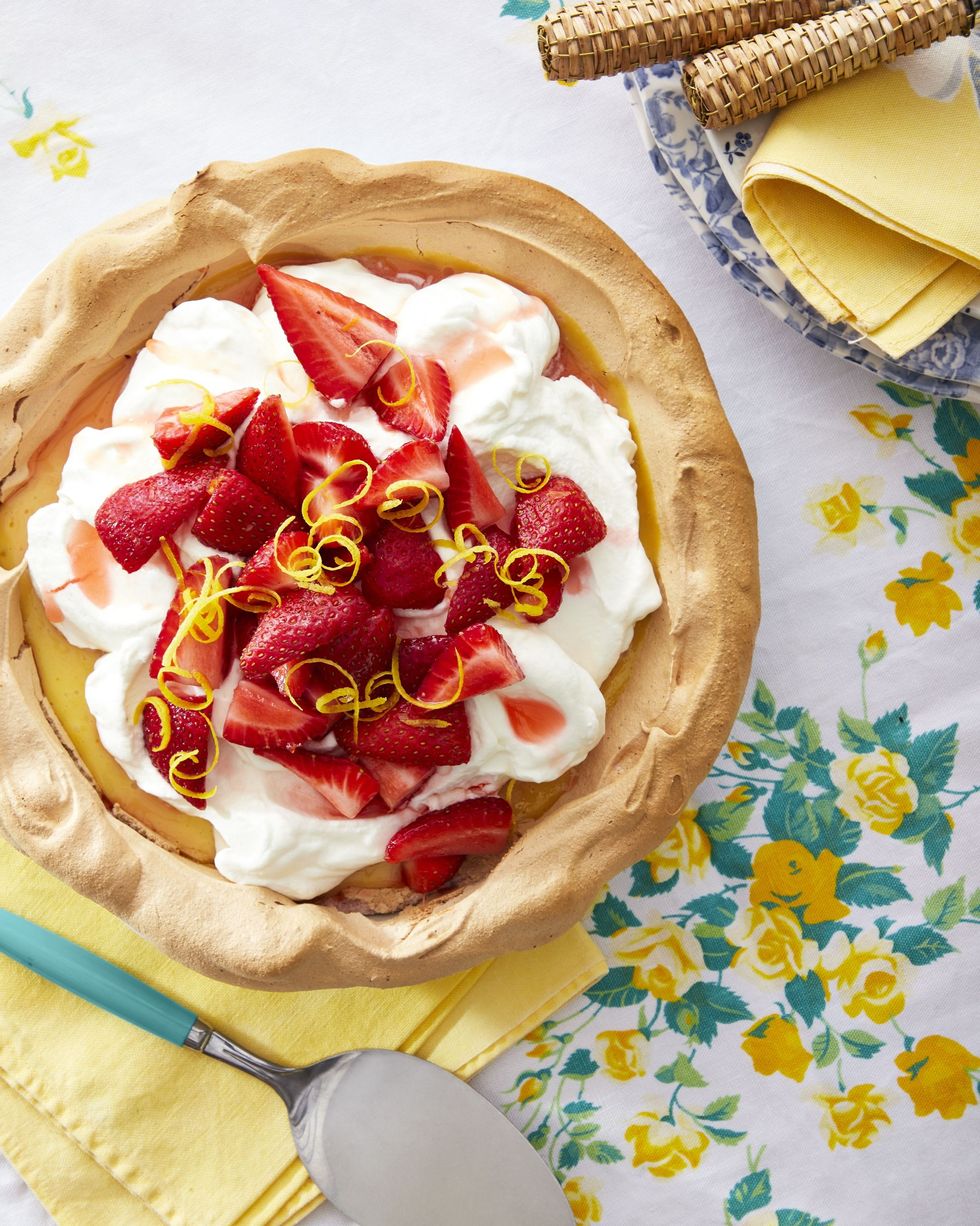 strawberry lemonade angel pie with a meringue shell and tipped with whipped cream sliced strawberries and lemon zest