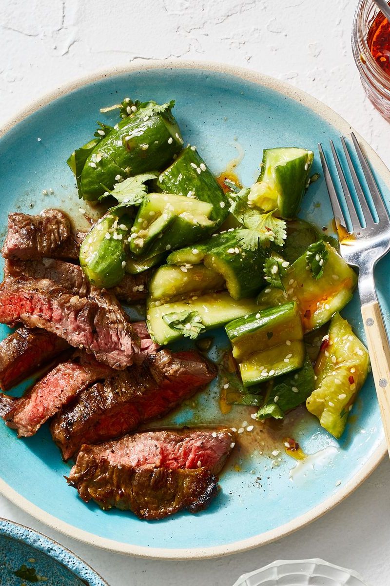 steak with smashed cucumber salad on a plate