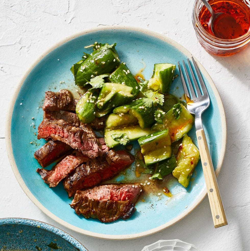 steak with smashed cucumber salad on a plate