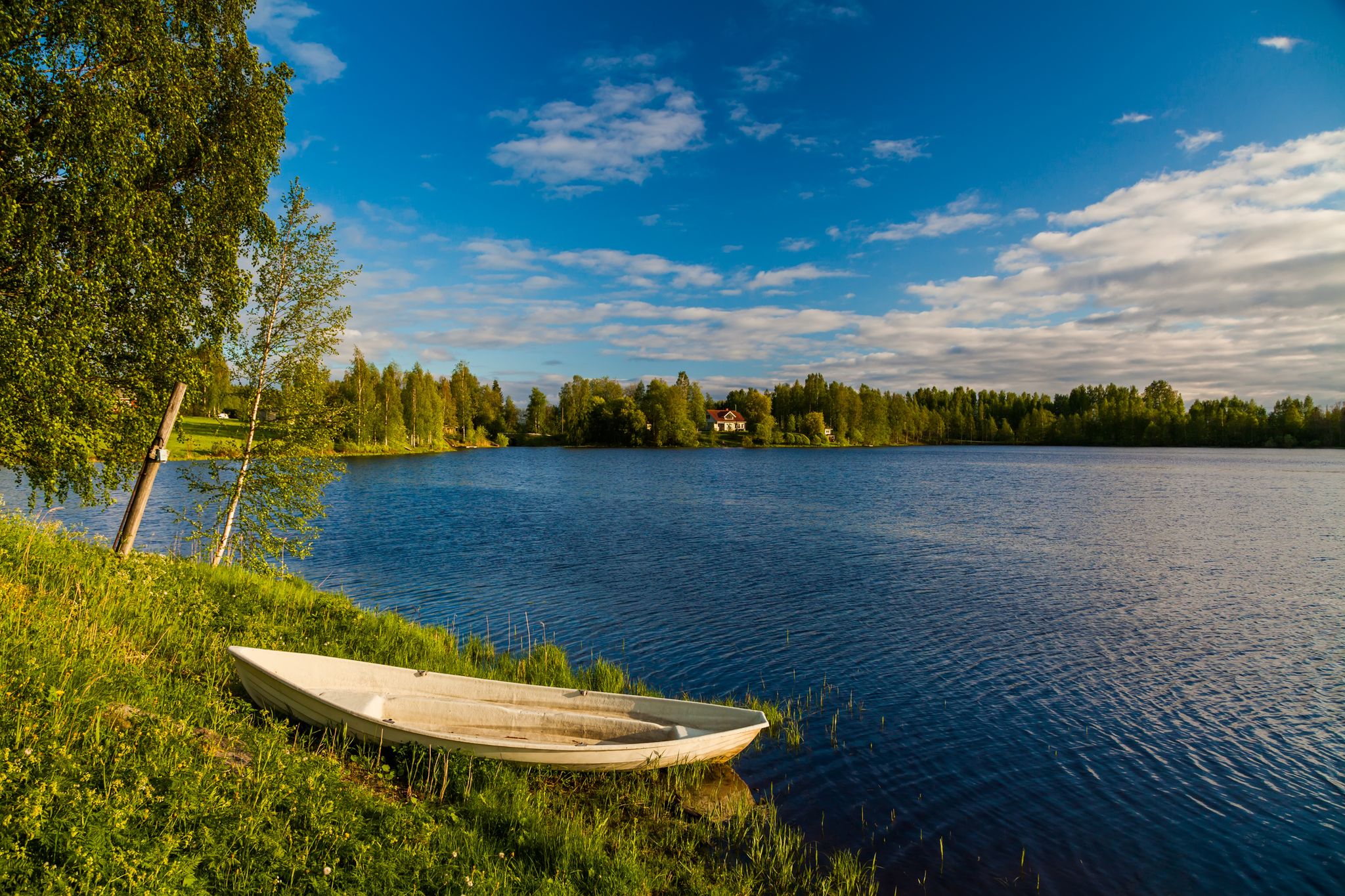 summer lake with a fishing boat on the beach finland