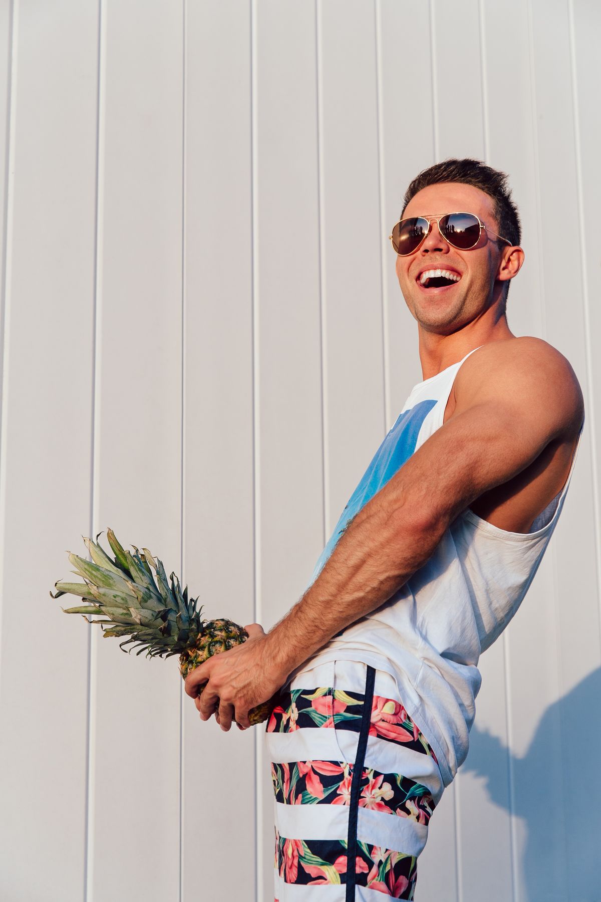 Summer photo of joyful man with pineapple.