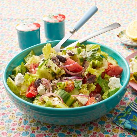 greek salad with tomatoes cucumbers olives in blue bowl