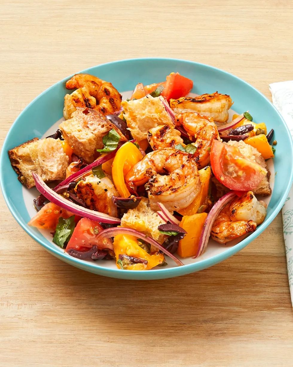 grilled shrimp panzanella with tomatoes and red onions in bowl