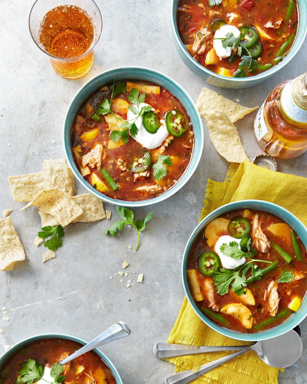 bowls of slow cooker chicken tortilla soup with sliced jalapenos and cilantro on top