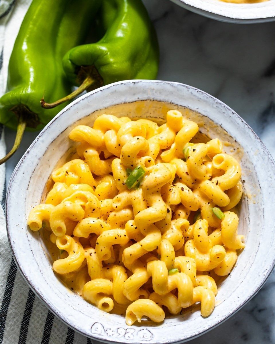 slow cooker mac and cheese with green chile in a white bowl