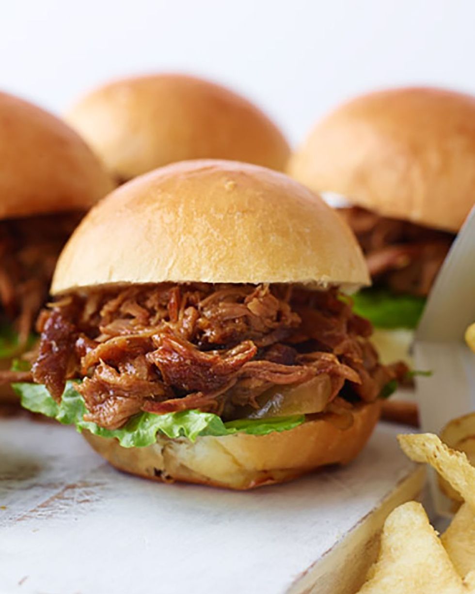 pulled pork sliders on a white wooden serving board