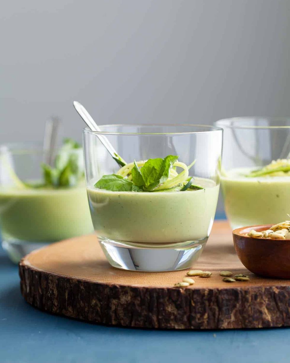 chilled zucchini basil soup in glasses with spoon
