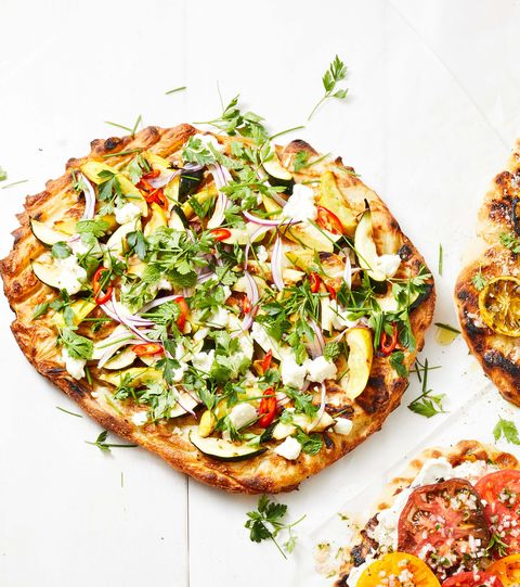 summer squash pizza with fresh green herbs on top