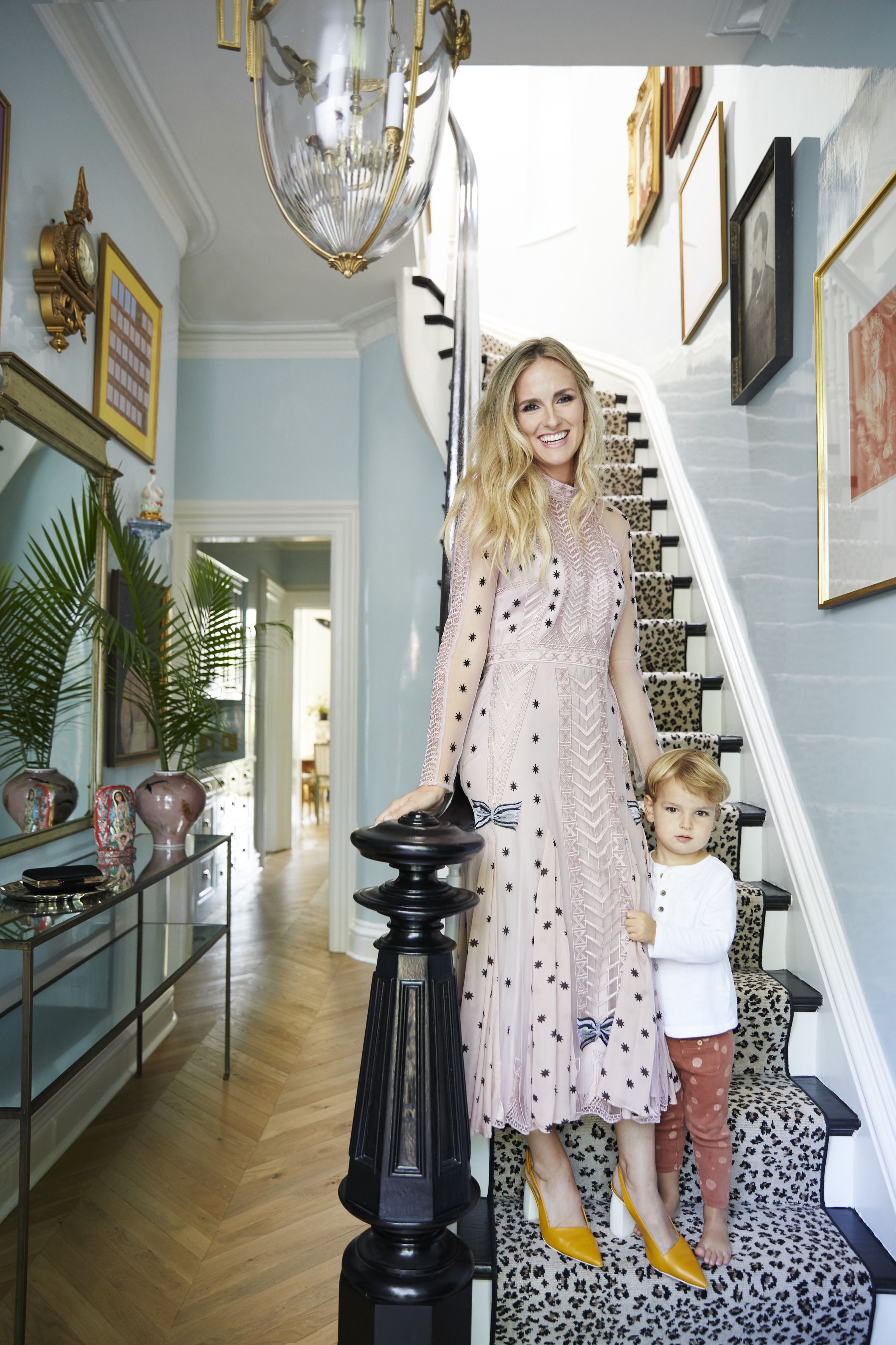 summer and her son welcome guests on an entry stairwell cloaked in panther print carpet