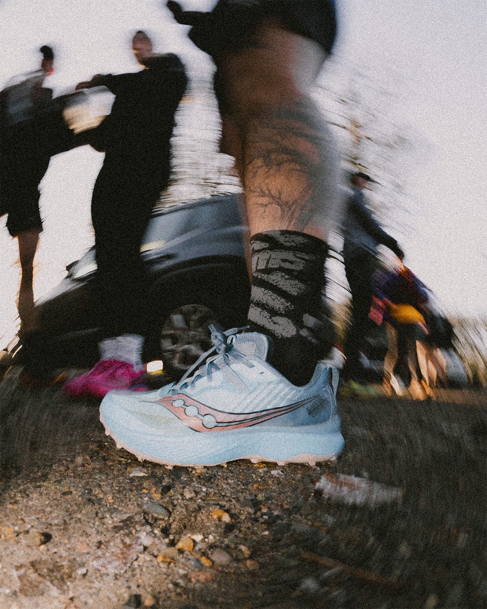 running shoe on a gravel surface with blurred background activity