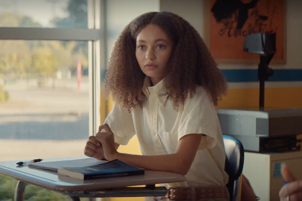 Nico Parker en Suncoast, una mujer joven sentada en un escritorio en un salón de clases