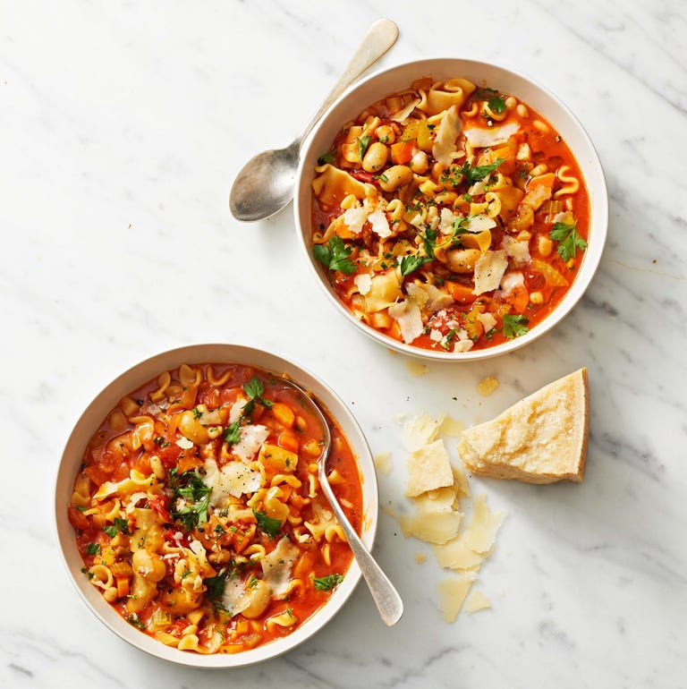 two bowls of pasta e fagioli with a red sauce