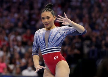 suni lee raises her hands while competing at the 2024 us olympic team trials in gymnastics