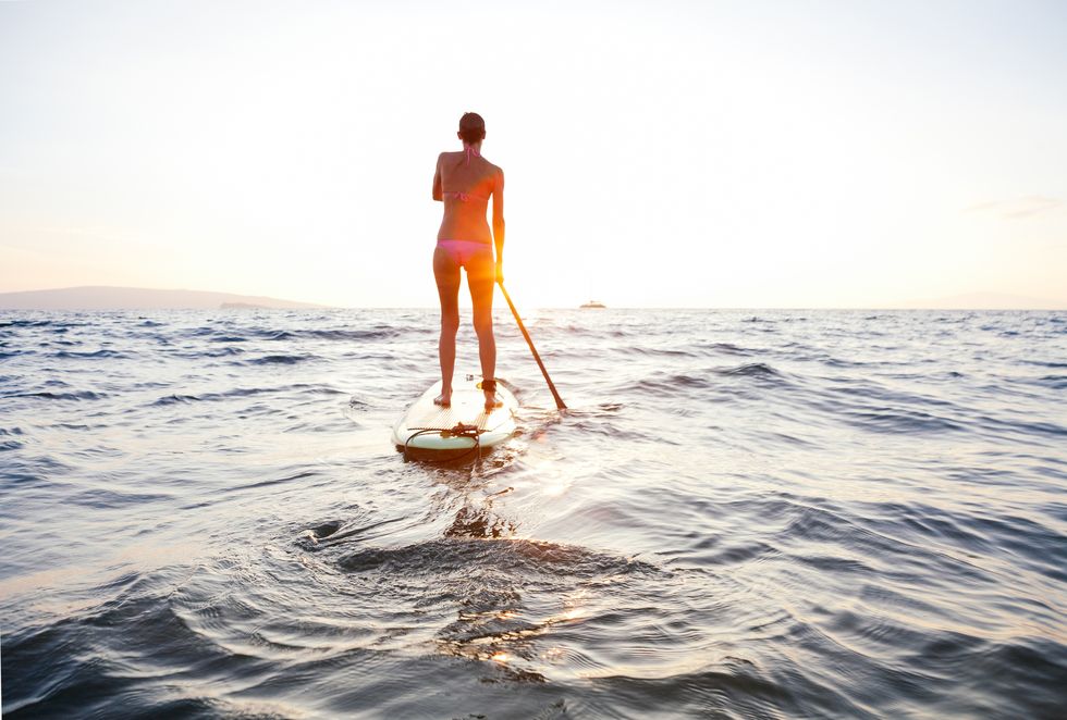 woman goes for a sunlight paddle in hawaii