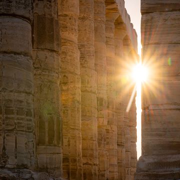 sunrays through the ancient greek temple of poseidon in sounio, greece