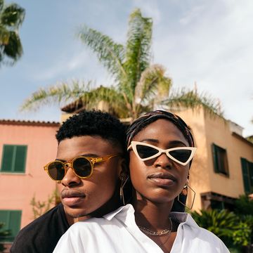 man and woman wearing sunglasses in front of palm trees