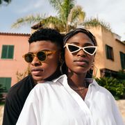 man and woman wearing sunglasses in front of palm trees