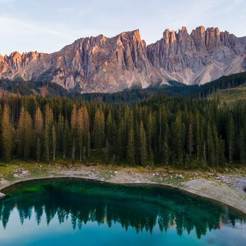 sunset over lake carezza karersee and latemar massif in dolomites