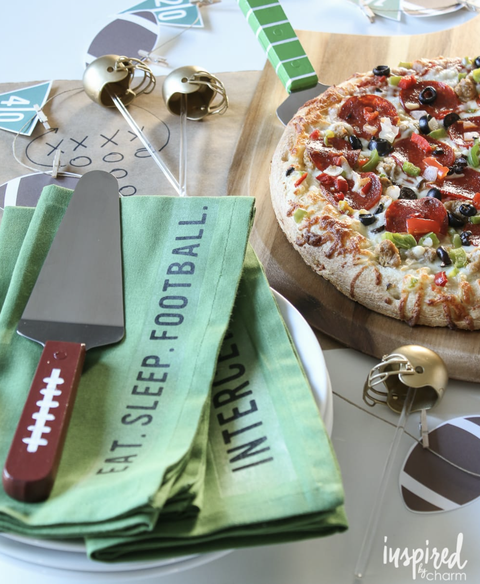 super bowl party ideas, football themed napkins next to pizza on a plate