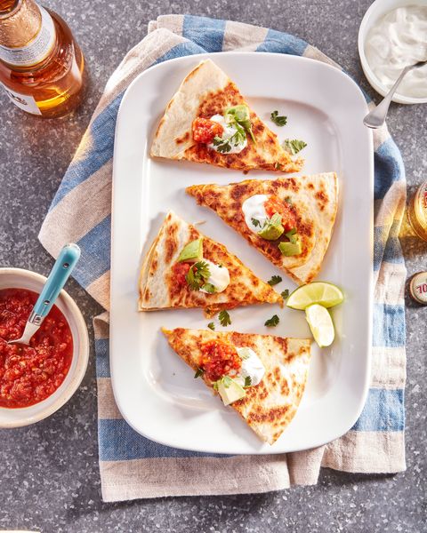 chicken quesadillas cut into triangles and arranged on a white rectangular plate