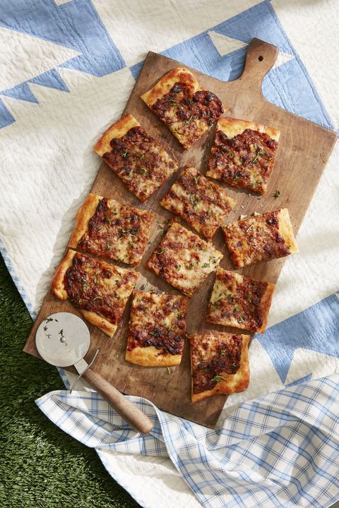 french onion flatbread on a wooden serving board cut into squares