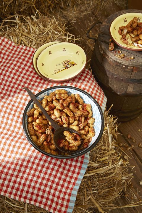 spiced roasted peanuts in a bowl with a spoon for serving on a red gingham tablecloth
