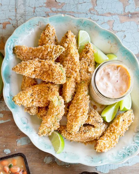 oven avocado fries with a small mason jar of dipping sauce and lime wedges on the side